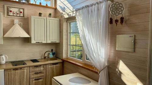a small bathroom with a sink and a window at Naujos statybos namelis in Palanga