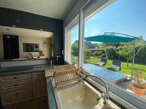 une cuisine avec un évier et une grande fenêtre dans l'établissement La maison d'à coté, gîte en bord de Rance, à Le Minihic-sur-Rance