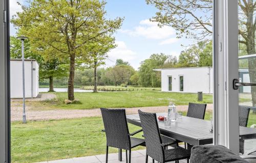 a table and chairs on a patio with a view of a yard at Lovely Home In Ringkøbing With Kitchen in Ringkøbing