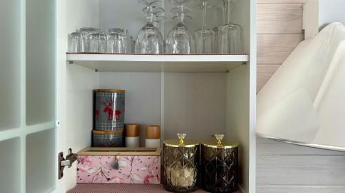 a cupboard with glasses and other items on it at Naujos statybos namelis in Palanga