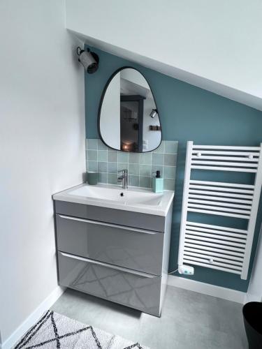 un baño con lavabo y espejo en Maison Biscaya , La chambre 2e étage, en Caro