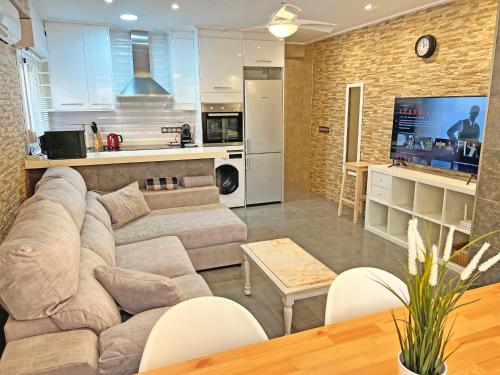a living room with a couch and a kitchen at A 150 metros del Mar, Parking Gratis, AC in Santa Pola
