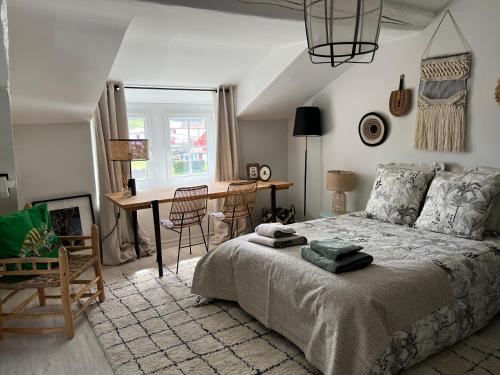 Un dormitorio con una cama, una mesa y un escritorio. en Maison Biscaya , La chambre 2e étage, en Caro