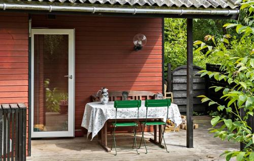 a table with green chairs on a patio at Awesome Home In Jægerspris With Wifi in Jægerspris