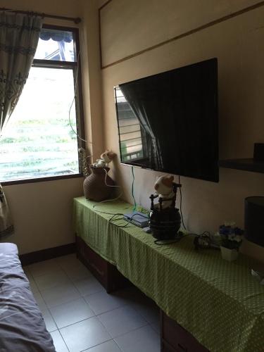a room with a television on a table with stuffed animals at Eco House in Bangkok