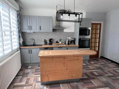 - une cuisine avec des placards blancs et un îlot en bois dans l'établissement Gîte de Kerg’O, à Cléden-Poher