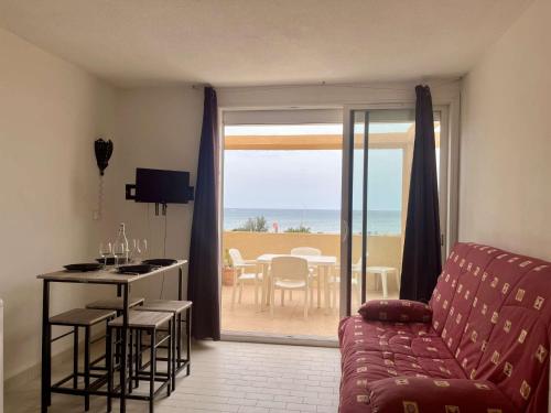 a living room with a couch and a view of the ocean at Studio Cabine 4 couchages PORT LEUCATE NATURISME PL080-TA21 in Port Leucate