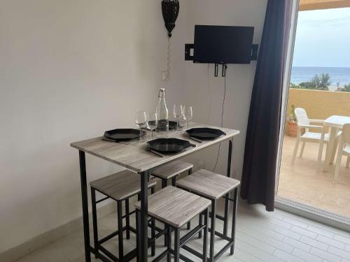 - une table avec des verres à vin et un balcon dans l'établissement Studio Cabine 4 couchages PORT LEUCATE NATURISME PL080-TA21, à Port-Leucate