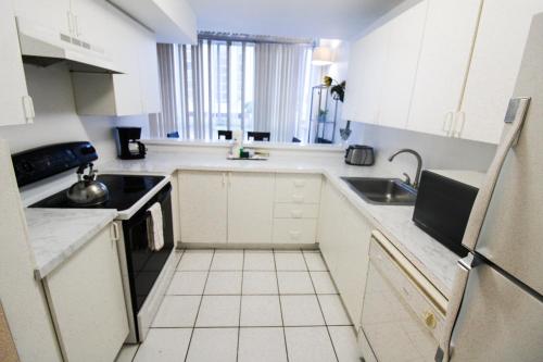 a white kitchen with a sink and a refrigerator at Castle B6 in Miami Beach