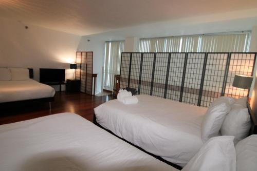 a bedroom with two beds with white sheets at Castle B6 in Miami Beach