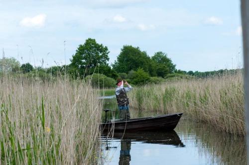 a man is standing on a boat in the water at La Grande Métairie Notz Marafin in Paulnay