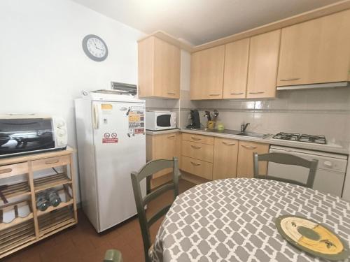 une cuisine avec une table et un réfrigérateur blanc dans l'établissement 5070 Mas de la pinède 300, au Cap d'Agde