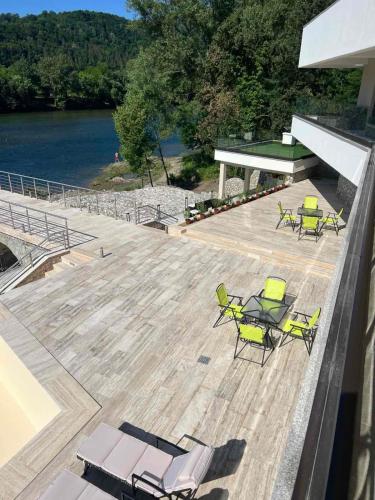a group of chairs on a deck next to the water at Orlovo gnezdo in Ljubovija