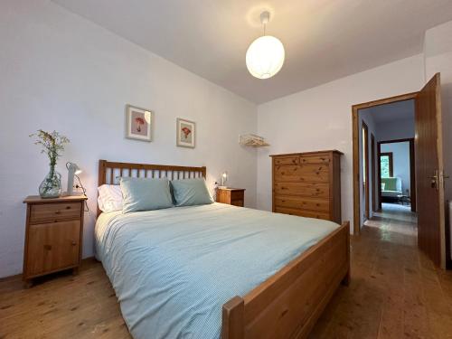 a bedroom with a bed and a dresser and a mirror at La Torre de la Vall de Camprodon in Llanars