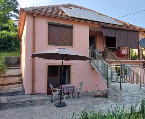 a table with an umbrella in front of a house at Apartman Pavle Virpazar in Virpazar