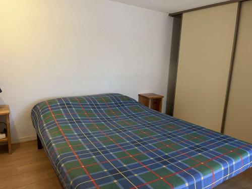 - une chambre dotée d'un lit avec une couverture tressée dans l'établissement Maison cabine mezzanine 6 couchages PORT LEUCATE NATURISME PL070-103, à Port-Leucate