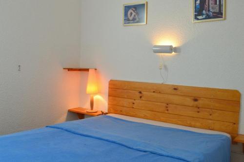 - une chambre dotée d'un lit bleu avec une lumière sur le mur dans l'établissement Appart 2 pièces 4 couchages PORT LEUCATE NATURISME PL010-452, à Port-Leucate