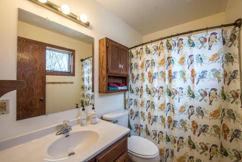 a bathroom with a sink and a shower curtain at Dream House, a Creative Escape in the Heart of Powderhorn in Minneapolis