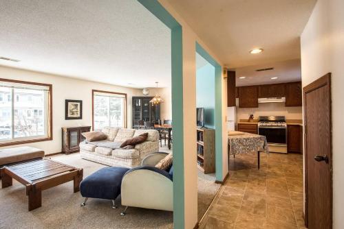 a living room with a couch and a table and a kitchen at Dream House, a Creative Escape in the Heart of Powderhorn in Minneapolis
