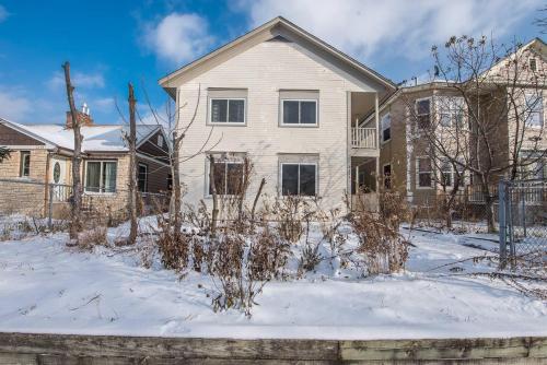 a white house with snow on the ground at Dream House, a Creative Escape in the Heart of Powderhorn in Minneapolis