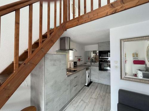 une grande cuisine avec un escalier en bois dans une maison dans l'établissement Maison 2 pièces résidence EDEN PORT LEUCATE NATURISME PL070-119, à Port-Leucate