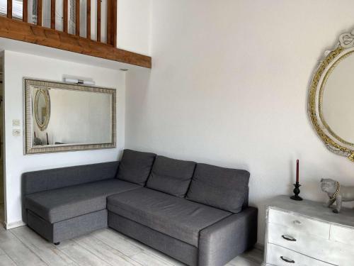 un salon avec un canapé et un miroir dans l'établissement Maison 2 pièces résidence EDEN PORT LEUCATE NATURISME PL070-119, à Port-Leucate