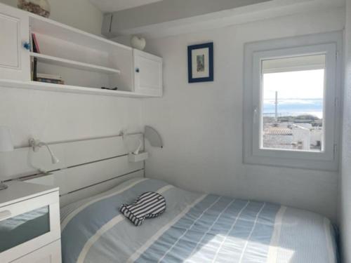 - une petite chambre avec un lit et une fenêtre dans l'établissement Les Terrasses de la Plage 268 , T2 climatisé, vue mer, parking, terrasse, au Cap d'Agde