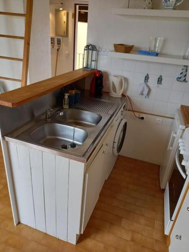 Il comprend une petite cuisine avec un évier et un comptoir. dans l'établissement Les Terrasses de la Plage 268 , T2 climatisé, vue mer, parking, terrasse, au Cap d'Agde