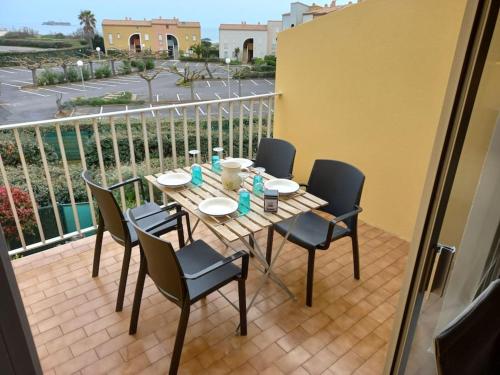 une table et des chaises sur un balcon avec vue dans l'établissement Les Terrasses de la Plage 268 , T2 climatisé, vue mer, parking, terrasse, au Cap d'Agde