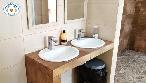 a bathroom with two sinks and two mirrors at Camping.Karystos Melodia in Karistos