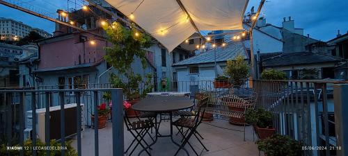 un patio con tavolo e sedie su un balcone di La piccionaia - Le Case del Dria - Roof terrace a Genova