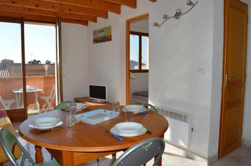 une salle à manger avec une table et des chaises en bois dans l'établissement Appart 3 pièces mezz 6 couchages PORT LEUCATE NATURISME PL010-1406, à Port-Leucate