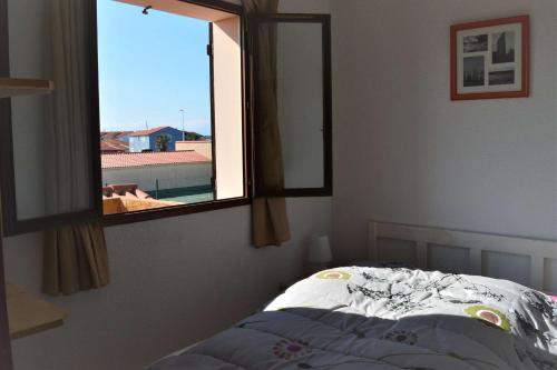 une chambre avec un lit et une fenêtre dans l'établissement Appart 3 pièces mezz 6 couchages PORT LEUCATE NATURISME PL010-1406, à Port-Leucate
