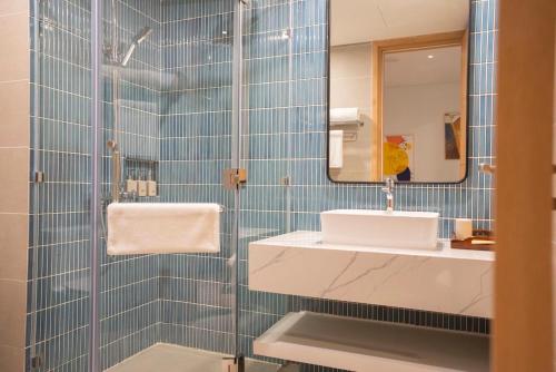 a bathroom with a sink and a mirror at FLAMINGo TÒA IBIZA, Hải Tiến in Thanh Hóa