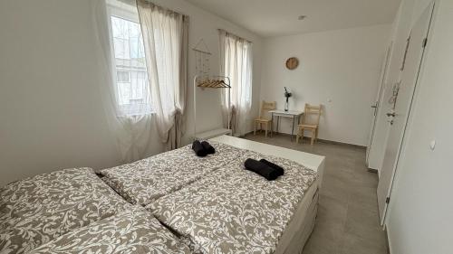 a bedroom with a bed with two black shoes on it at Langenzersdorf Apartment in Langenzersdorf