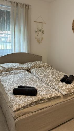 a bed with two black towels on top of it at Langenzersdorf Apartment in Langenzersdorf