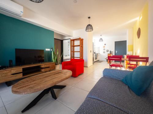 a living room with a couch and a tv at Évasion Saint-Leu in Saint-Leu