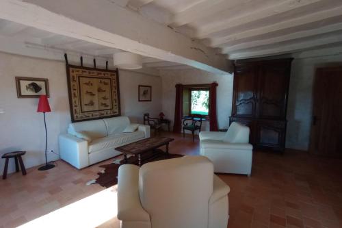 a living room with white furniture and a table at La Grande Métairie Notz Marafin in Paulnay