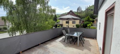 a balcony with a table and chairs and an umbrella at FeWoaufdemAdenberg in Goslar