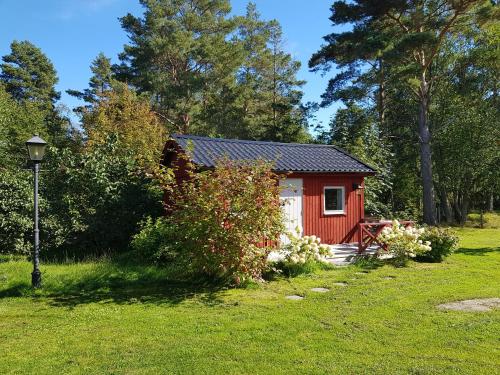a small red house in a grassy yard at Södra Kärr 4 in Gränna