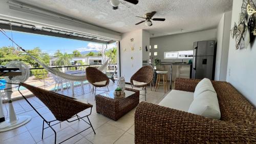 a living room with a couch and chairs and a balcony at Hermoso Apartasol!! cerca a Plaza Principal, Aire Acondicionado, Vista a la Piscina in Santa Fe de Antioquia