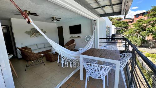 a porch with a hammock and a table and chairs at Hermoso Apartasol!! cerca a Plaza Principal, Aire Acondicionado, Vista a la Piscina in Santa Fe de Antioquia