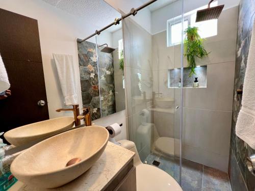 a bathroom with two sinks and a glass shower at Hermoso Apartasol!! cerca a Plaza Principal, Aire Acondicionado, Vista a la Piscina in Santa Fe de Antioquia