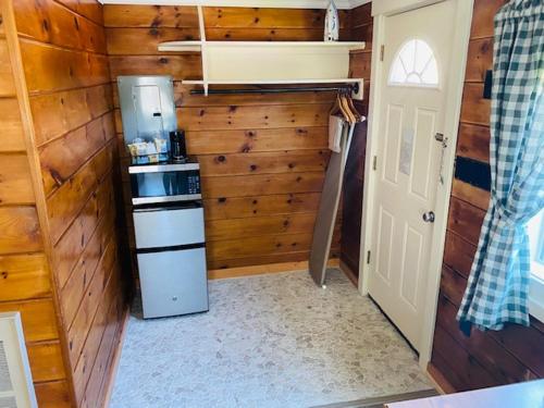 a small kitchen with a refrigerator and wooden walls at Senator Inn & Spa in Augusta