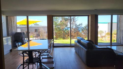 a living room with a couch and a table at La boite à coucou, Appartement pour 6 personnes, avec jardin , vue mer, à 400 m de la plage pors mabo in Trébeurden