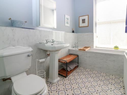Un baño con un inodoro blanco y un lavabo. en 1A Carmelite Street, en Banff