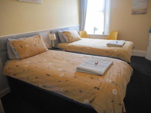 een hotelkamer met 2 bedden en handdoeken erop bij The George B&B in Weymouth