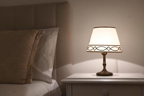 a lamp sitting on a table next to a bed at Casa FEREMI in Cavallino di Lecce