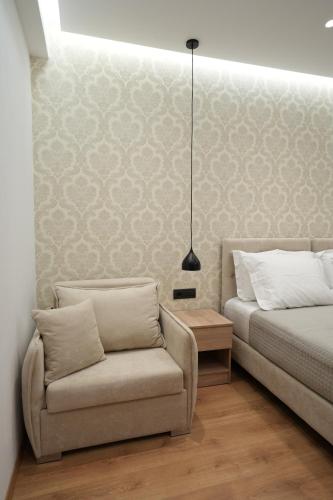 a bedroom with a bed and a couch and a lamp at Villa Qeli in Gjirokastër
