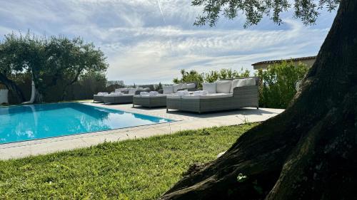a swimming pool with couches and a swimming pool at Villa C Luxury Estate in SantʼAntonio Abate